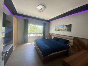 1 dormitorio con cama azul e iluminación púrpura en Marina Agadir - Luxury Pool view apartment 2Bdr, en Agadir