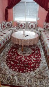 uma sala de estar com uma mesa e um sofá em Appartement Stade Tanger em Tânger