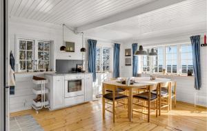 - une cuisine blanche avec une table et des chaises en bois dans l'établissement 2 Bedroom Beautiful Home In Kge, à Køge