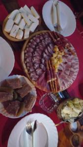 a table topped with different types of bread and cheese at Domaćinska kuća in Arandjelovac