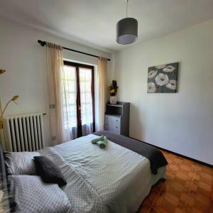 a bedroom with a bed and a window at Casa delle azalee in Gravellona Toce