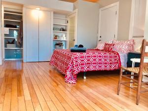 een slaapkamer met een bed met een rode en witte deken bij Cozy Poolside Studio in Durham