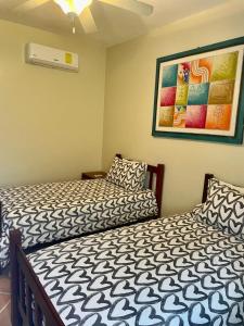ein Schlafzimmer mit 2 Betten und einem Wandgemälde in der Unterkunft Disfruta de tus vacaciones en Bávaro/Punta Cana in Punta Cana
