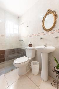 a bathroom with a toilet and a sink and a mirror at Acogedor Espacio en Santo Domingo Este. in Mandinga