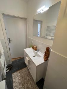 a bathroom with a white sink and a mirror at Bilk Apartment in Düsseldorf