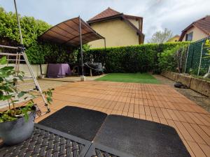 een achtertuin met een bakstenen patio met een parasol bij Alpes Golden Nest in Chambéry