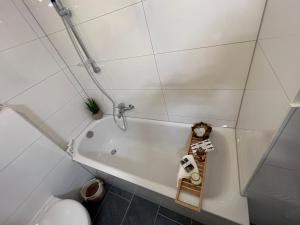 a white bathroom with a tub and a toilet at Bilk Apartment in Düsseldorf