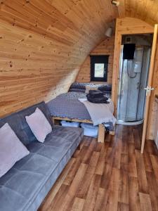 una sala de estar con sofá en una cabaña de madera en Lochview Pods, en Harlosh