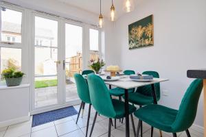 a dining room with a table and green chairs at Evergreen House - Modern 4-bed Family, Contractors, Free Netflix, Fast WiFi, NEC, Resorts World, JLR, Airport in Solihull