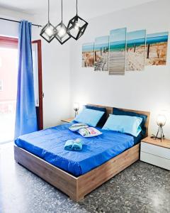 um quarto com uma cama com um edredão azul em Valverde75 Guesthouse em Alghero