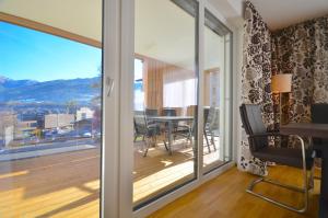 a room with a sliding glass door with a table and chairs at Alpin & Seeresort Top 10 - by Alpen Apartments in Zell am See