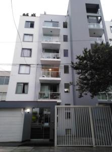 a white apartment building with a balcony at Mar Private Rooms in Lima