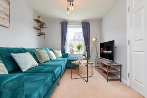 a living room with a green couch and a tv at Evergreen House - Modern 4-bed Family, Contractors, Free Netflix, Fast WiFi, NEC, Resorts World, JLR, Airport in Solihull