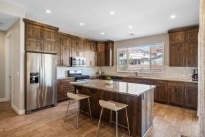 a kitchen with wooden cabinets and a stainless steel refrigerator at Red Sand Hideaway #119 home in Santa Clara