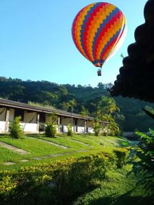 kolorowy balon z gorącym powietrzem latający nad polem w obiekcie Pousada Campestre São Lourenço w mieście São Lourenço