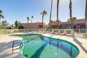 a swimming pool with chairs and palm trees at Golf Haven with Pool Access - 5 Mi to Palm Springs in Cathedral City
