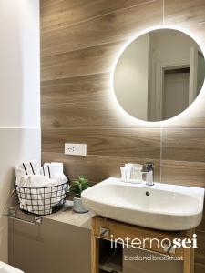 ein Badezimmer mit einem weißen Waschbecken und einem Spiegel in der Unterkunft Interno Sei B&B in Agropoli