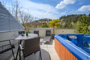 a hot tub on a balcony with a table at Apartmány Luhačovice, Royal in Luhačovice