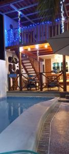 uma piscina com um deque e uma casa em Salv lodge casa frente al mar em Zorritos