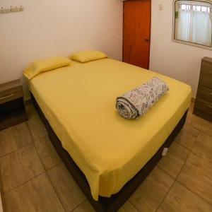 a yellow bed with a towel on top of it at Salv lodge casa frente al mar in Zorritos