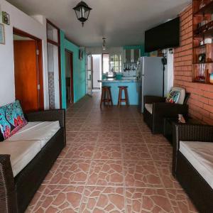 a living room with two couches and a kitchen at Salv lodge casa frente al mar in Zorritos