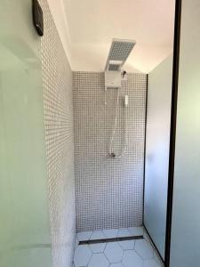 baño con ducha y puerta de cristal en Casa do Jardim en Serra Grande