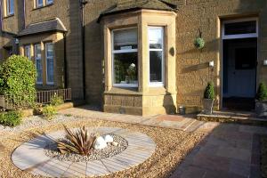 a house with a garden in front of a building at Dalmore Lodge Guest House in Edinburgh +39 photos