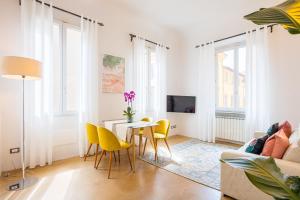 salon ze stołem i żółtymi krzesłami w obiekcie Condotta 16 Apartments we Florencji