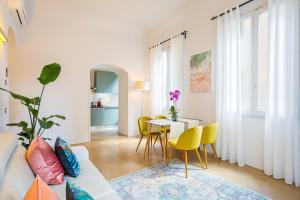 Condotta 16 Apartments في فلورنسا: غرفة معيشة مع أريكة وطاولة مع كراسي صفراء