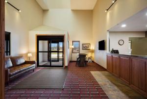 een woonkamer met een bank en een televisie bij Best Western Vermillion Inn in Vermillion