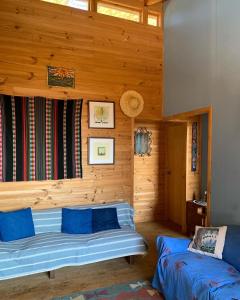 a bedroom with wooden walls and a bed with blue pillows at Laguna Verde, linda casa con vista al mar y privacidad in Laguna Verde
