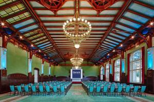 een grote kamer met stoelen en een podium erin bij Dorint Herrenkrug Parkhotel Magdeburg in Maagdenburg