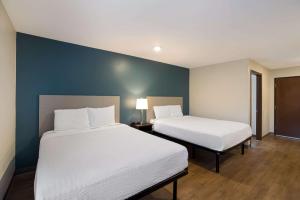 Habitación con 2 camas y pared azul en WoodSpring Suites Orlando North - Maitland, en Orlando