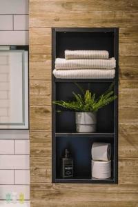 un estante con toallas y una planta en el baño en ComfySleep ApartHOUSE, en Glasgow