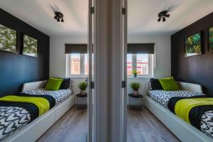 two beds in a room with windows at ComfySleep ApartHOUSE in Glasgow