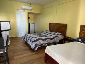 a bedroom with two beds and a door with a window at Plaza Real Resort in Juan Dolio