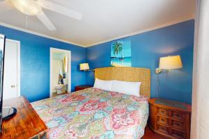 a blue bedroom with a bed and a wooden table at Abaco House in Gulf Shores