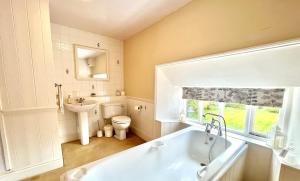 uma casa de banho com uma banheira, um WC e um lavatório. em Burnley country house em Hutton le Hole