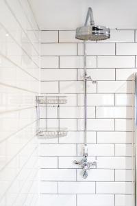 a shower in a bathroom with white subway tiles at The Vicarage in Holmes Chapel