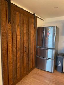 a kitchen with a stainless steel refrigerator and wooden walls at Casa finca, descanso en medio de la naturaleza . in Tabio