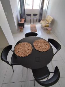 a black table and chairs in a room at Loft charmoso na zona Leste de Teresina in Teresina