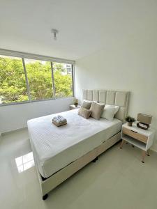 um quarto branco com uma cama grande e 2 janelas em Moderno apartamento amoblado via Ricaurte-Girardot em Ricaurte