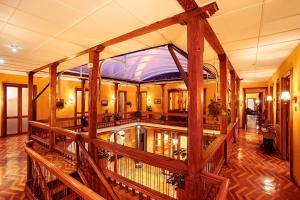 Großes Zimmer mit einem Holzgeländer in einem Gebäude in der Unterkunft Hotel Boutique La Merced in Pasto
