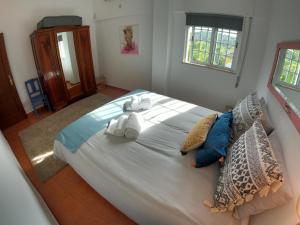 - une chambre avec un grand lit et des serviettes dans l'établissement Algarve, renovated T1 apartment in S Bras de Alportel, à São Brás de Alportel