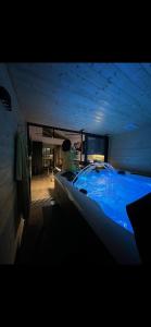 un uomo in una grande vasca blu in una stanza di Les suites de Stanislas jacuzzi & spa a Nancy