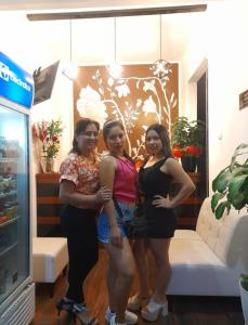 Hotel Betania في جيان: مجموعة من ثلاث نساء تقف في غرفة