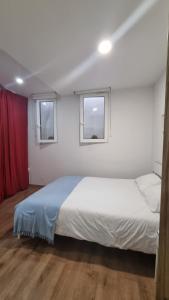 リスボンにあるCasa Intendenteのベッドルーム1室(白いベッド1台、窓2つ付)