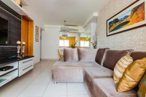 a living room with a couch and a tv at Apt incrível para sua família! Com churrasqueira in Cuiabá