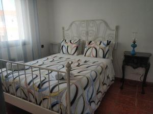 a bedroom with a bed with a white and blue comforter at Casa das Hortências By Alojamentos Vitinho - Vila Nova MIlfontes in Vila Nova de Milfontes