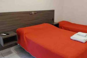 - une chambre avec 2 lits et des draps rouges dans l'établissement Premier, à Santiago del Estero